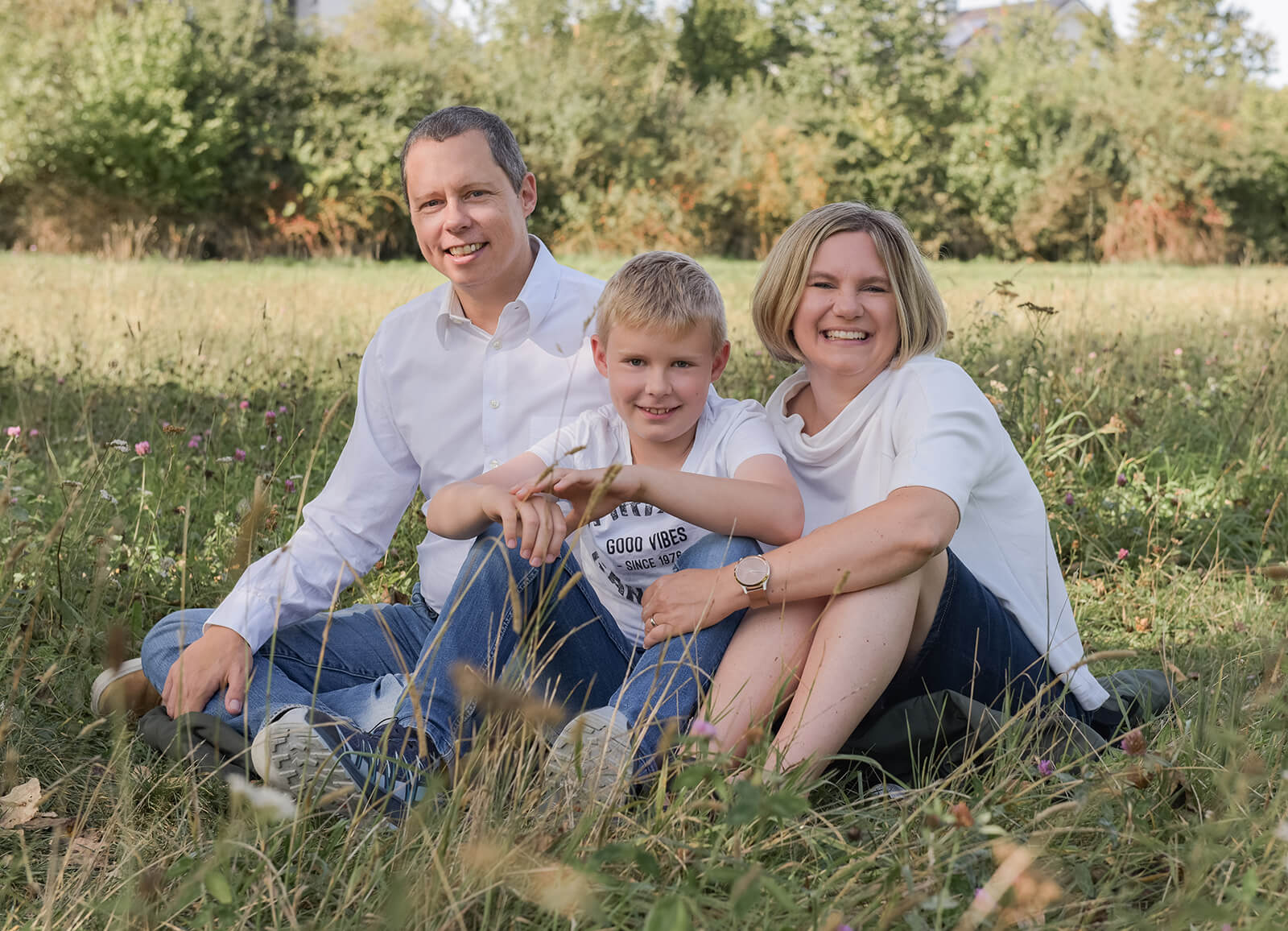 Familie sitzend im Gras bei Ottobrunn