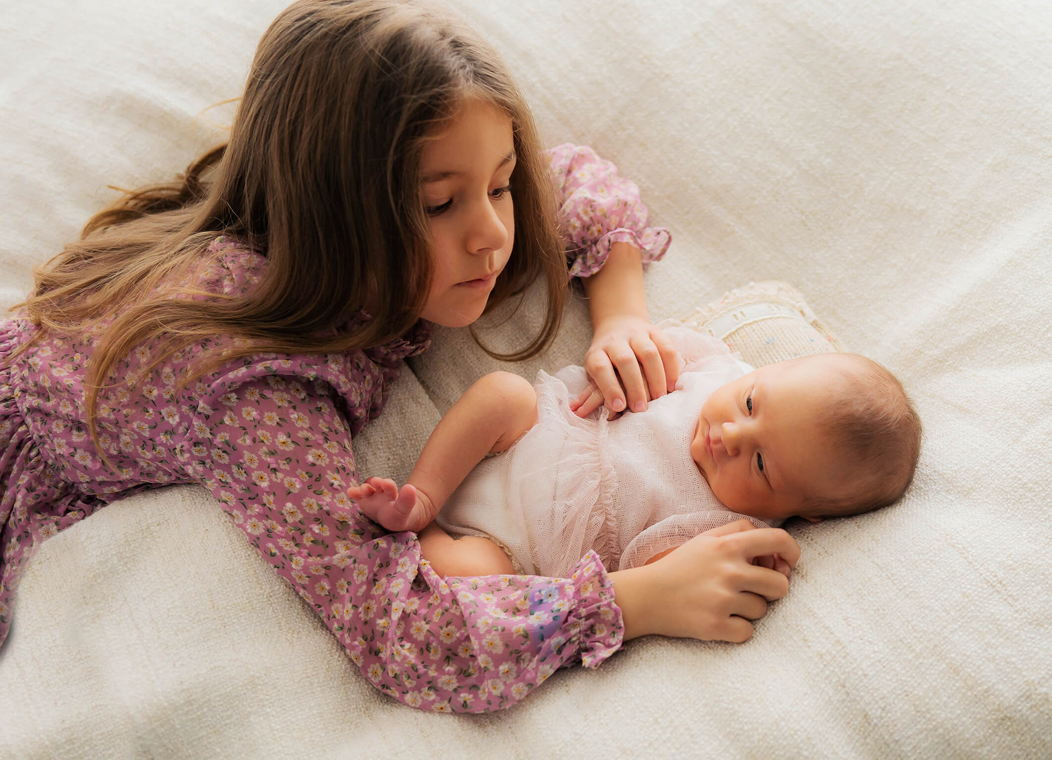 große Schwester mit Baby kuschelnd Trudering