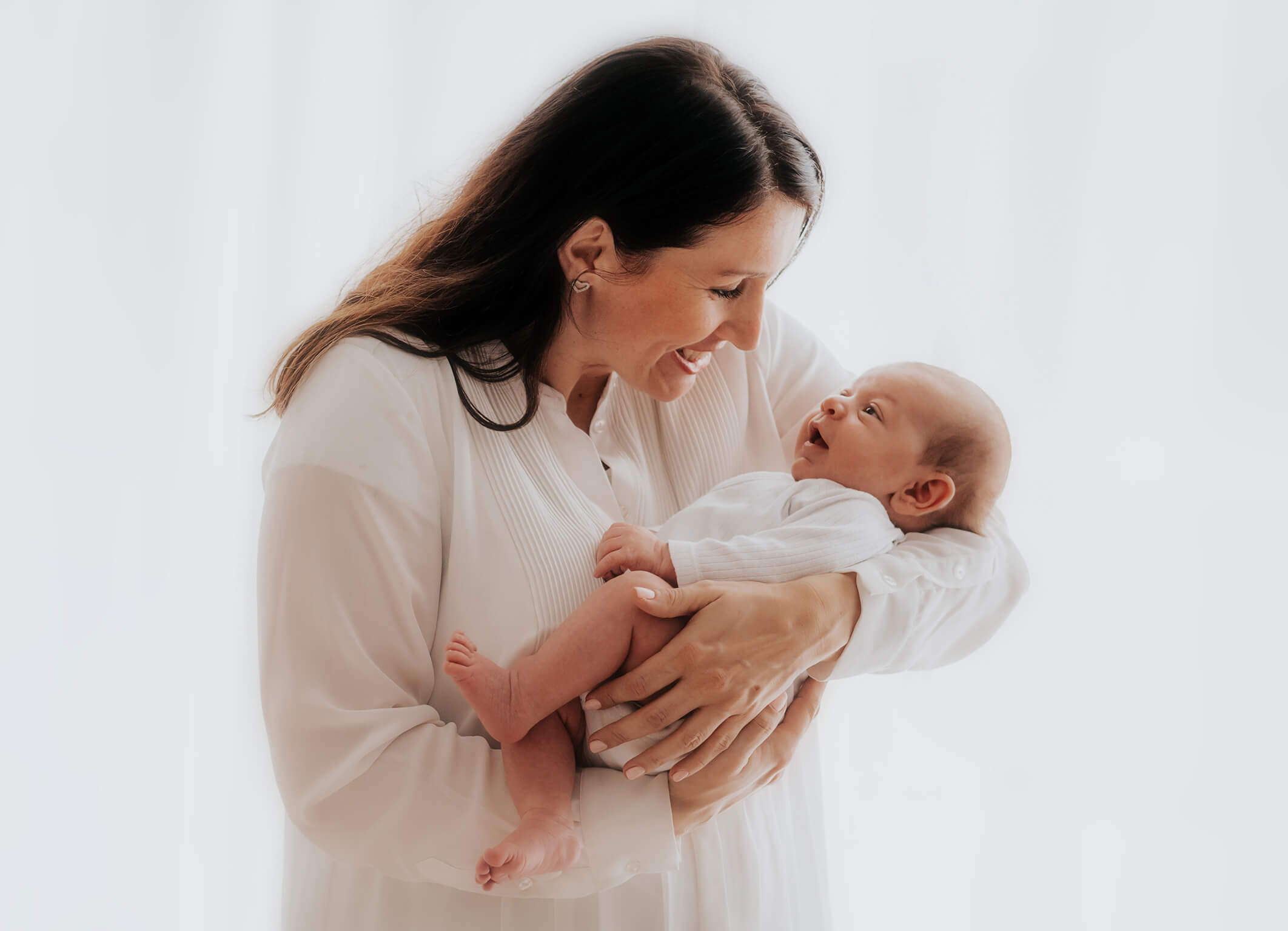 Mama mit Baby im Arm im Tageslichtstudio München