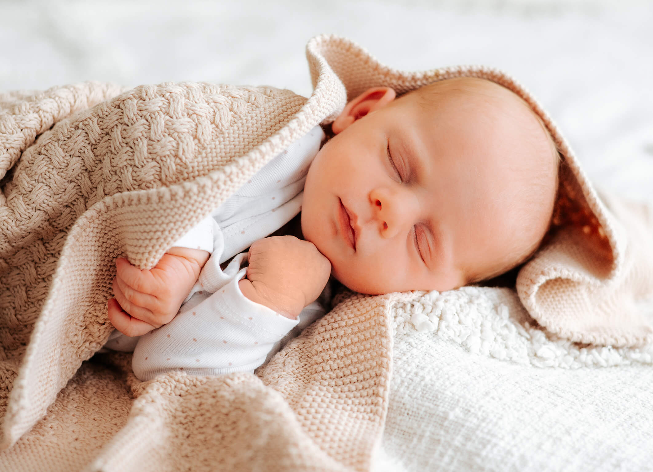 Baba schlafend in Decke gewickelt