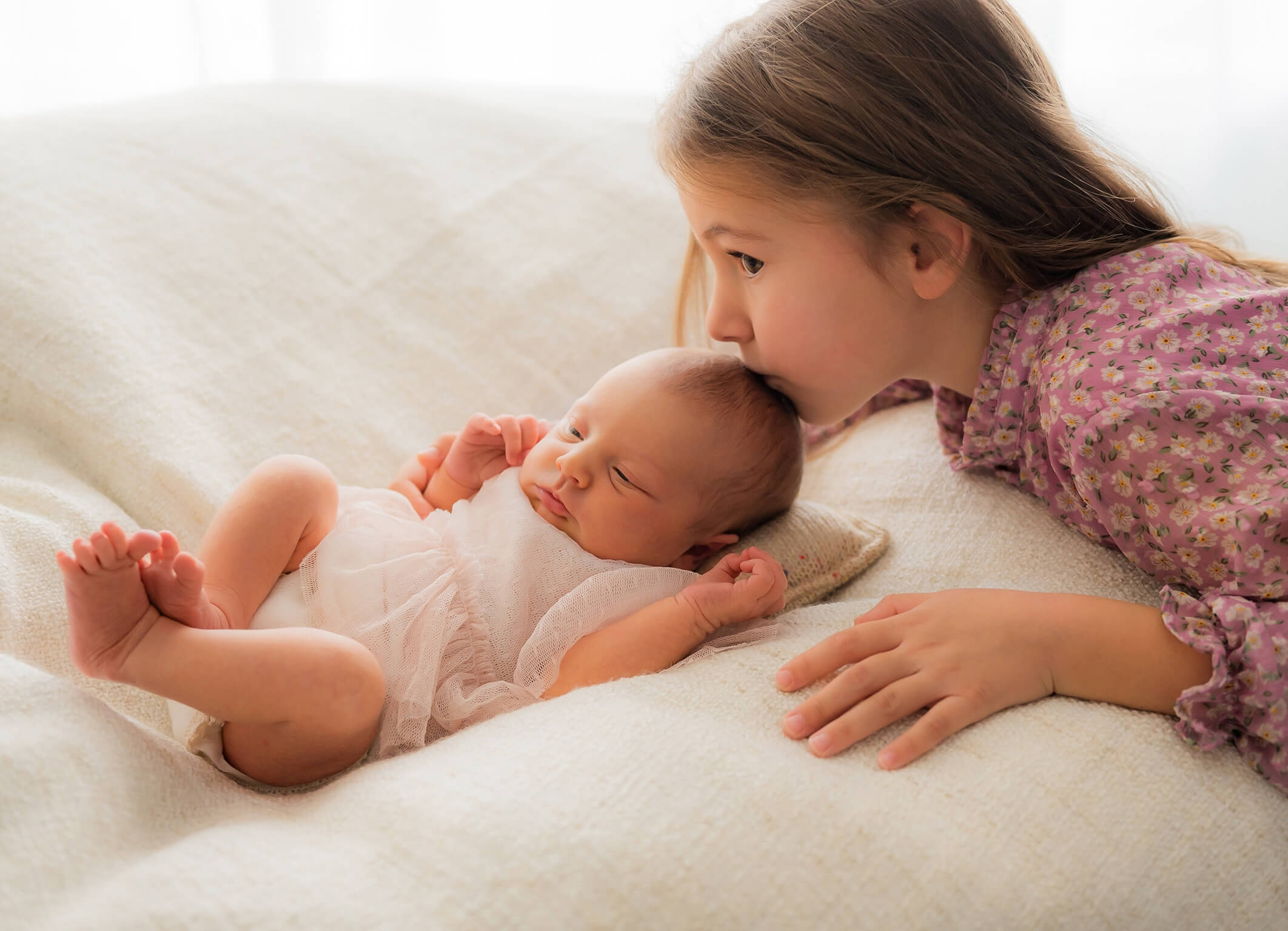 Schwester küsst kleinen Baby Bruder